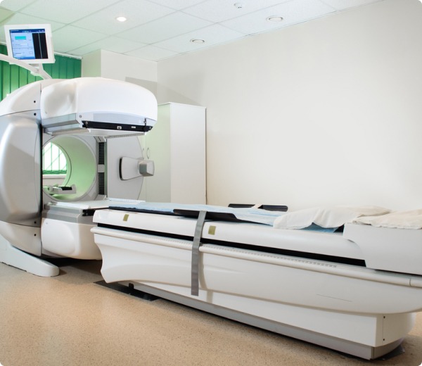 A modern medical imaging machine, ideal for diagnosing conditions like Dupuytrens contracture disease or Ledderhose disease, stands in a clean, well-lit room with a padded table and an attached monitor to view detailed results.