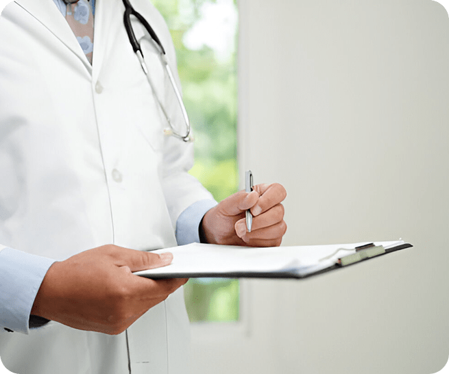 A doctor in a white coat holds a clipboard and pen, appearing to write notes about Dupuytren’s contracture disease. A stethoscope hangs around the neck. The background is bright and out of focus.