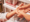 Close-up of one person gently massaging another’s palm with both hands, suggesting a hand therapy or relaxation treatment in a clinical or wellness setting, possibly as part of Dupuytrens contracture treatment UK.