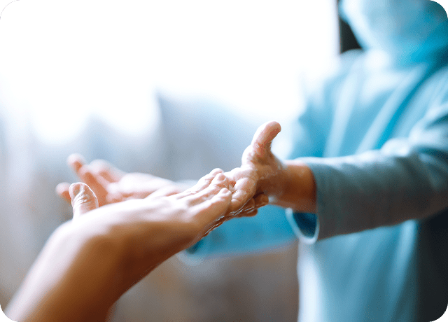 A child in a blue long-sleeve shirt applies soap to another persons hands, both with outstretched arms, highlighting proper handwashing and hygiene—important skills for all ages, including those affected by Dupuytrens contracture disease.