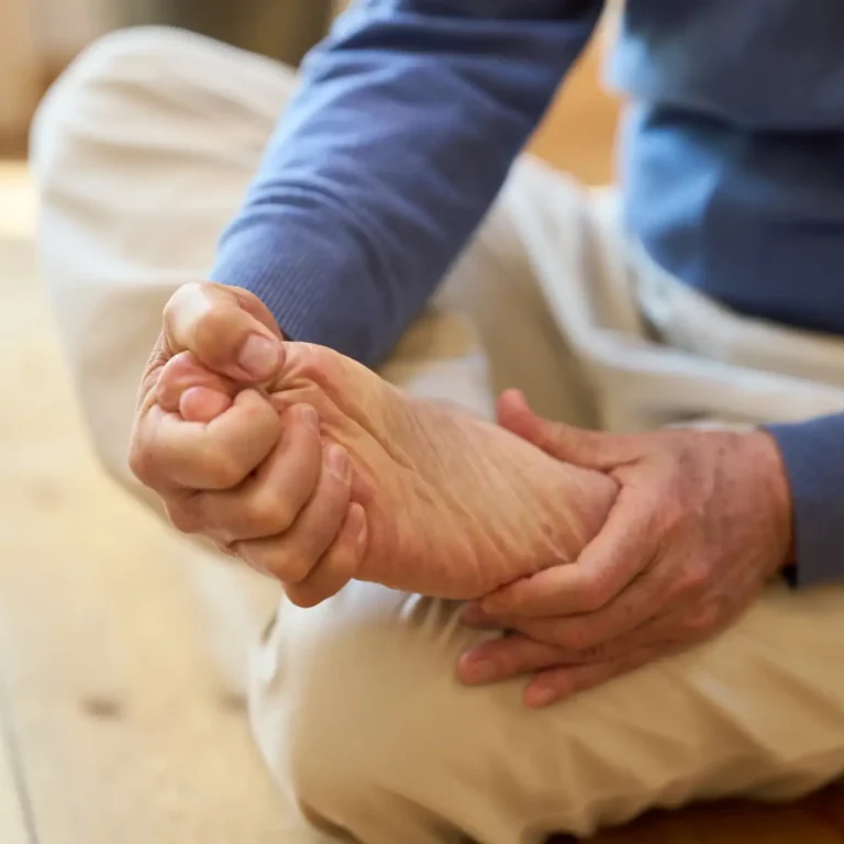 adult-massaging-foot-while-sitting-on-floor-indoor-2026-03-05-11-53-53-utc