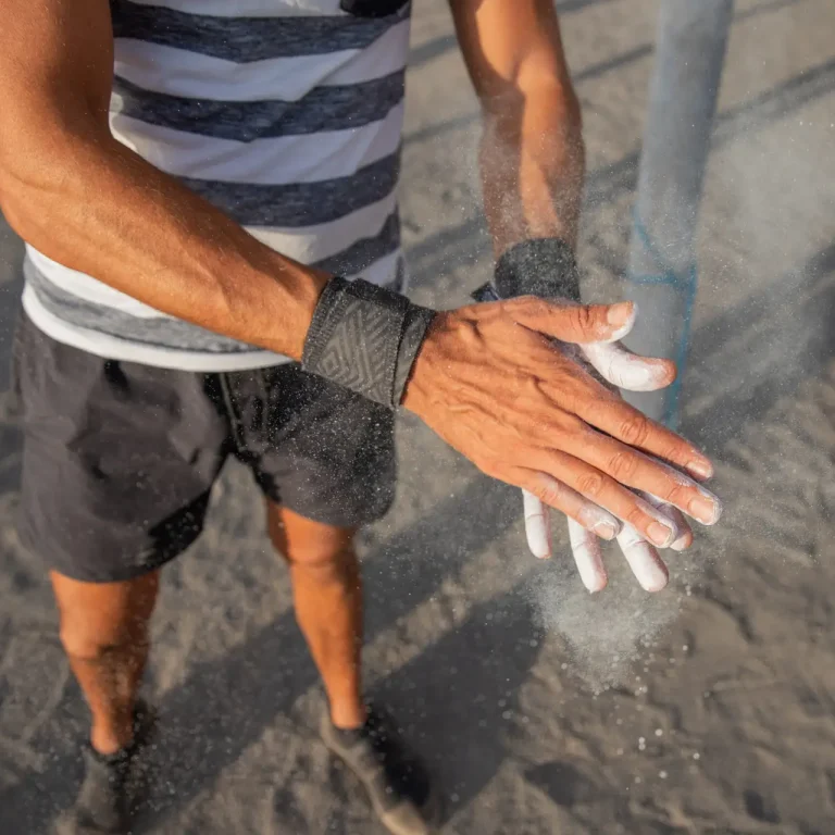 Portrait of an athlete's hands applying weightlifting Chalk Powder for training with weights - sportsman using equipment during training concept