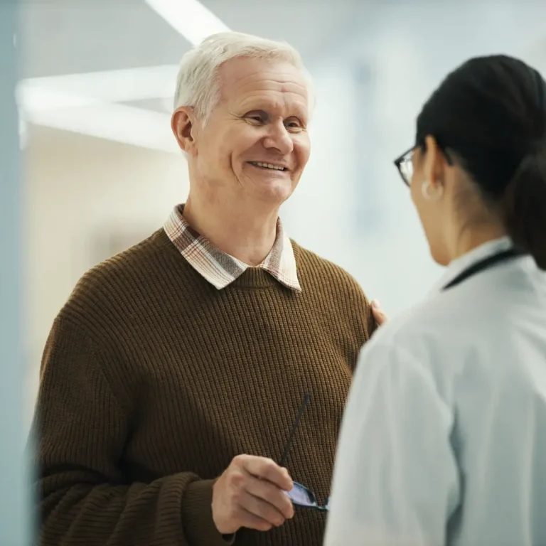 senior-man-smiling-while-consulting-female-doctor-2026-01-11-10-51-06-utc